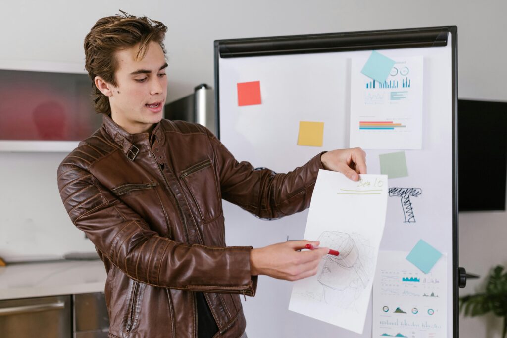 Young professional presenting data and charts at a business meeting indoors.